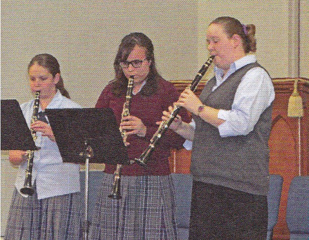 three people playing the clarinet